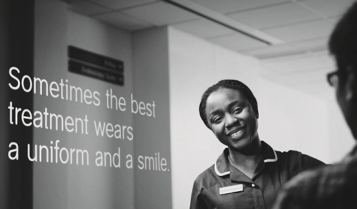 Black female nurse smiling at patient